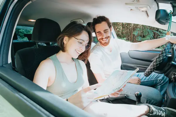Two people in a car looking at a map for a home location — Vision Realty